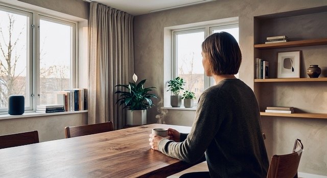 Persoon in kamer die alleen zit en overdenkt